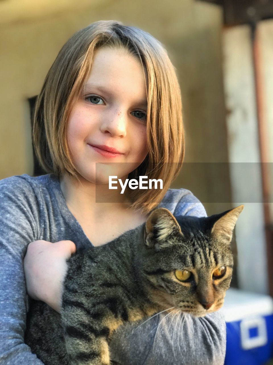 Portrait of smiling cute girl holding cat