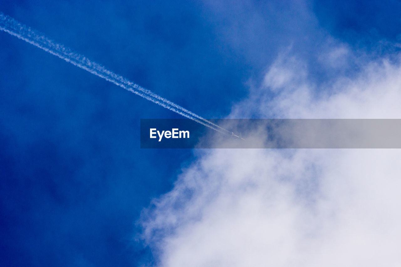 Low angle view of vapor trail against blue sky