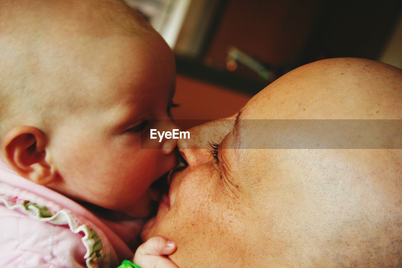 Close-up of woman kissing cute baby