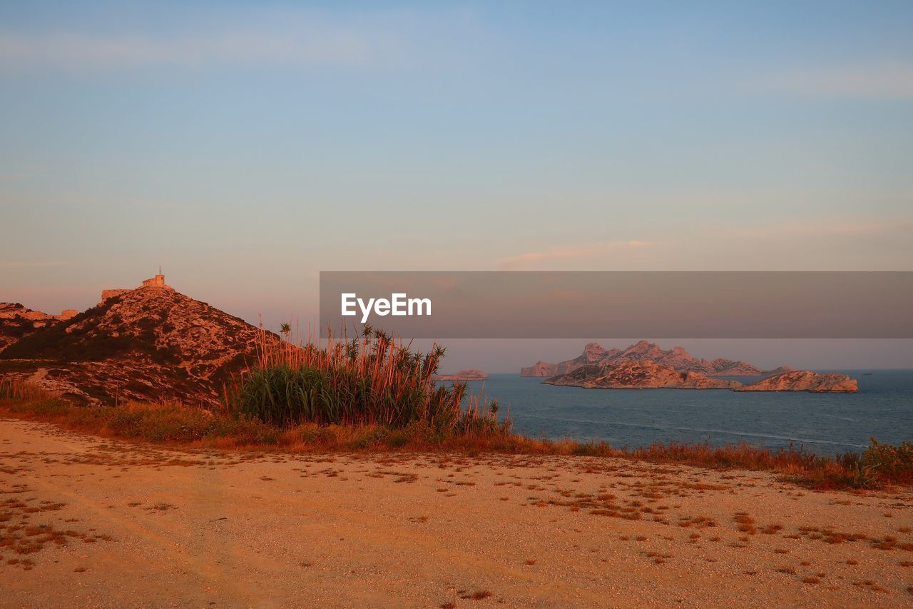 Scenic view of beach against sky during sunset