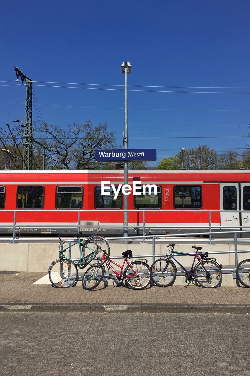 Bicycles parked by railing against train