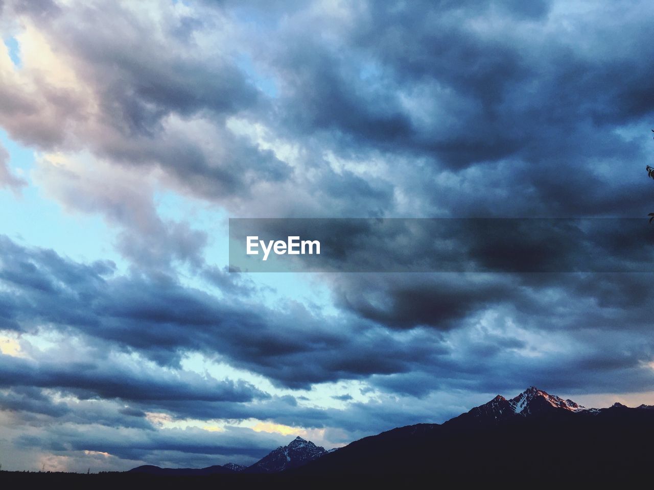 SILHOUETTE MOUNTAIN AGAINST DRAMATIC SKY