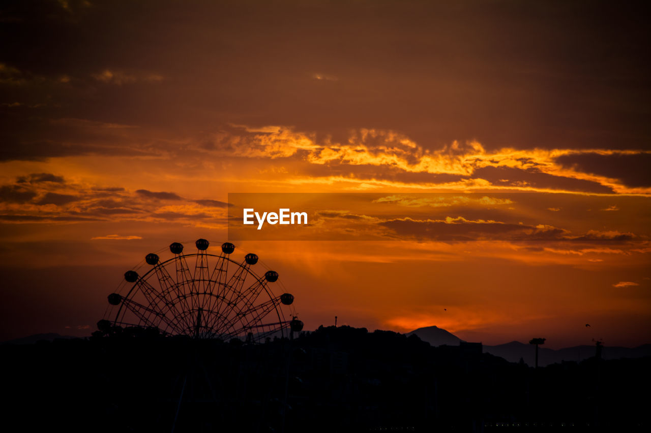 SILHOUETTE FERRIS WHEEL AGAINST ORANGE SKY DURING SUNSET