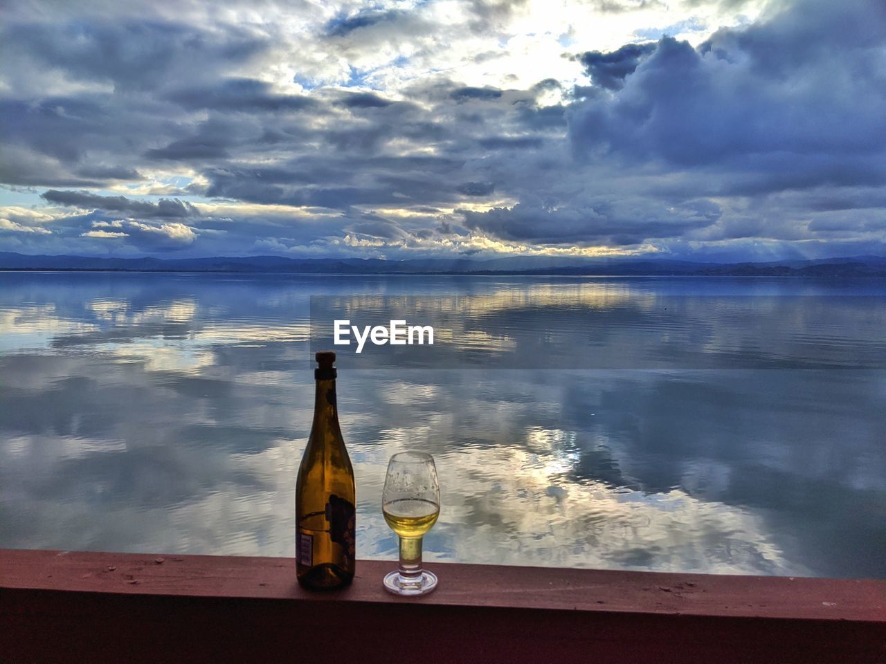 REFLECTION OF GLASS OF WATER ON TABLE