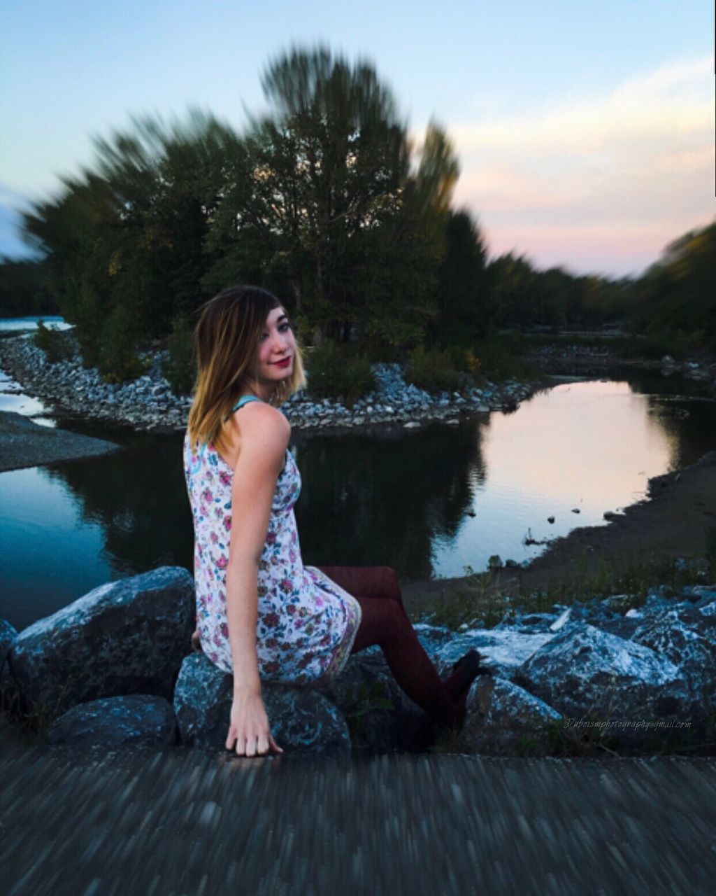 WOMAN STANDING ON PIER BY LAKE