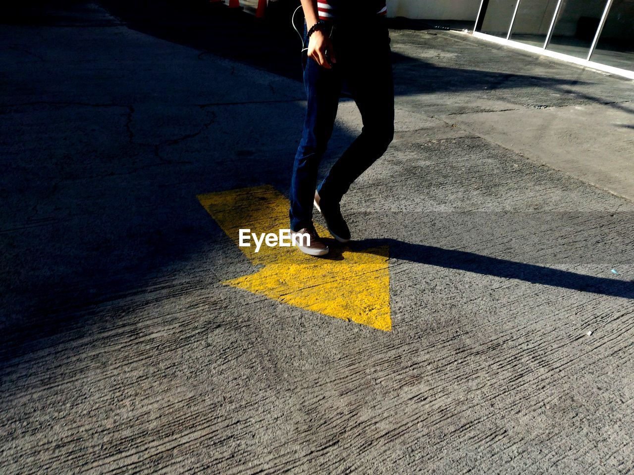 Low section of woman standing on road