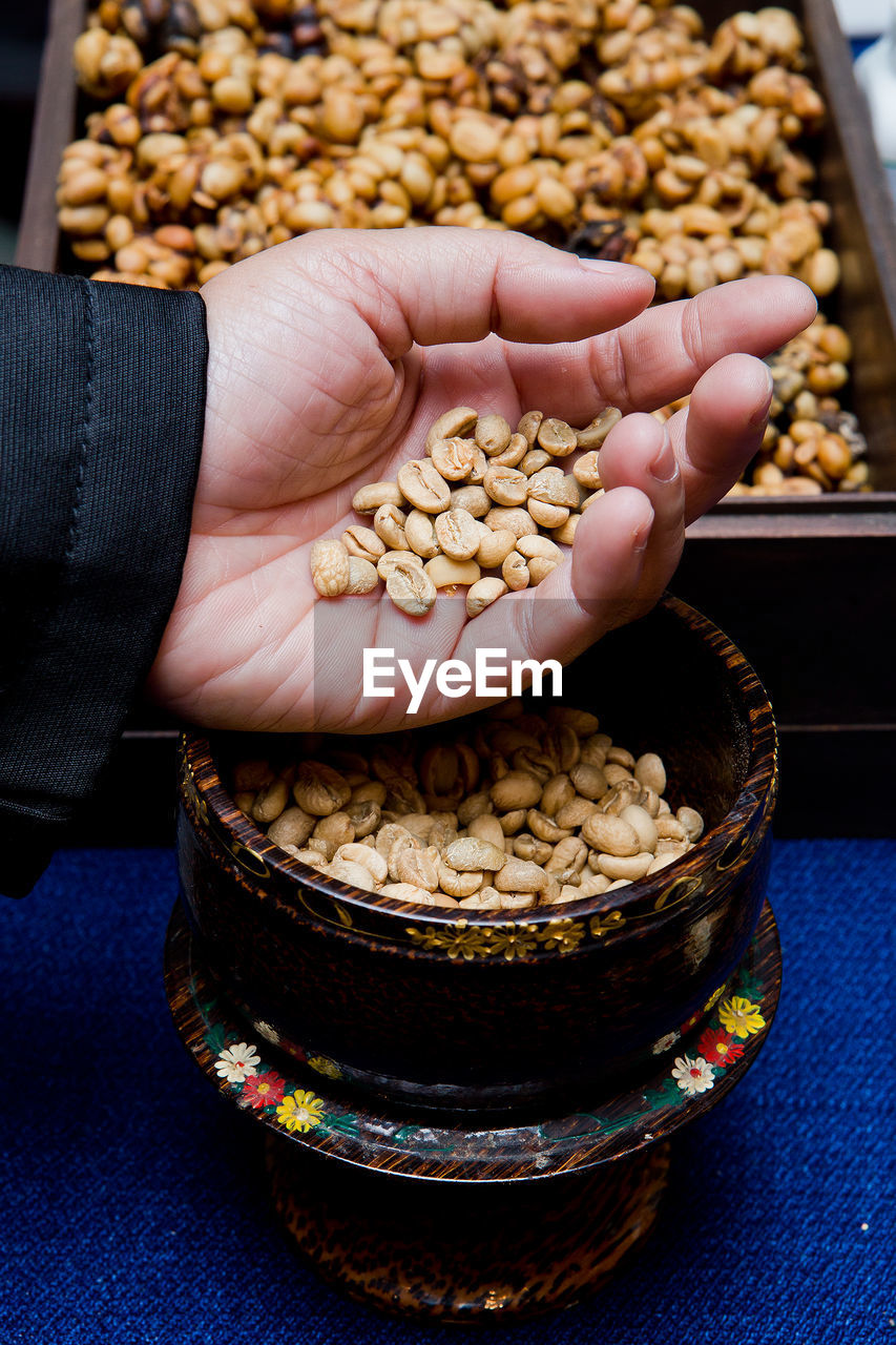 HIGH ANGLE VIEW OF PERSON HAND HOLDING FOOD