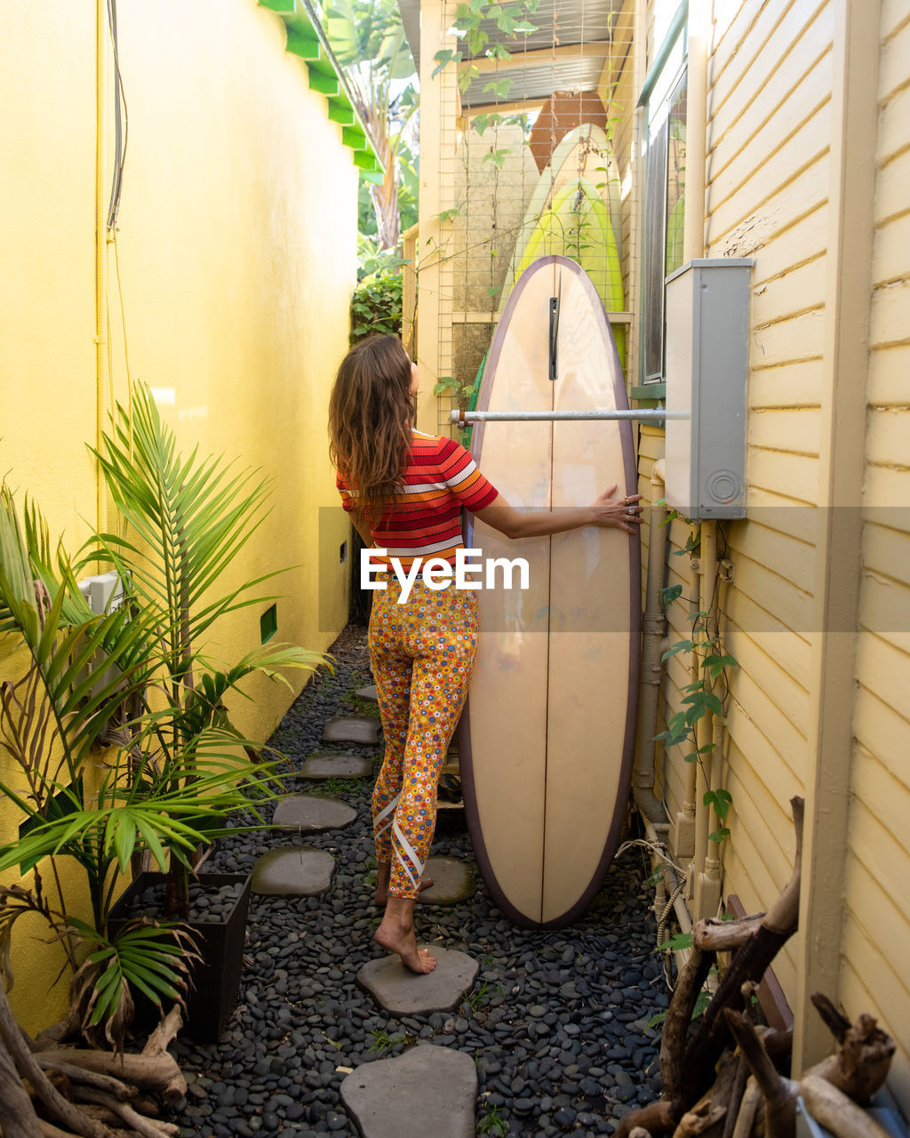 Female surfer organizes her surfboard collection