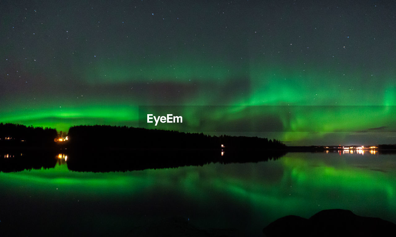 Scenic view of lake against sky at night