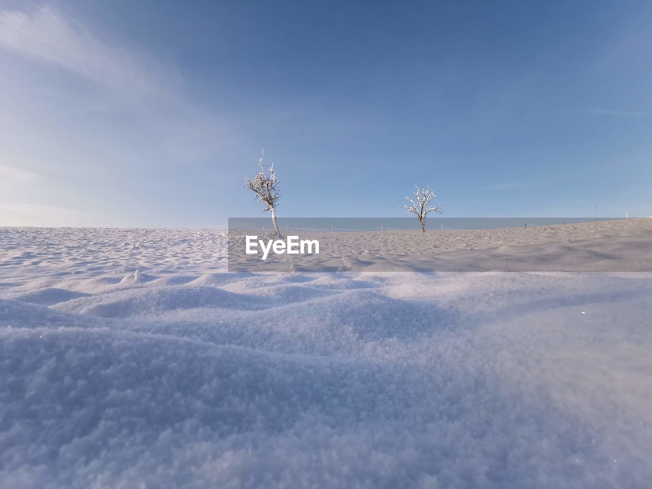 Scenic view of snow covered land against sky