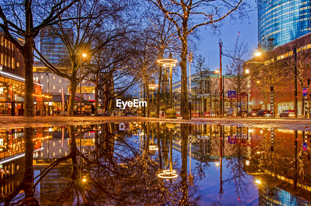 Large puddle after abundant rainfall reflecting the city lights on central coolsingel boulevard