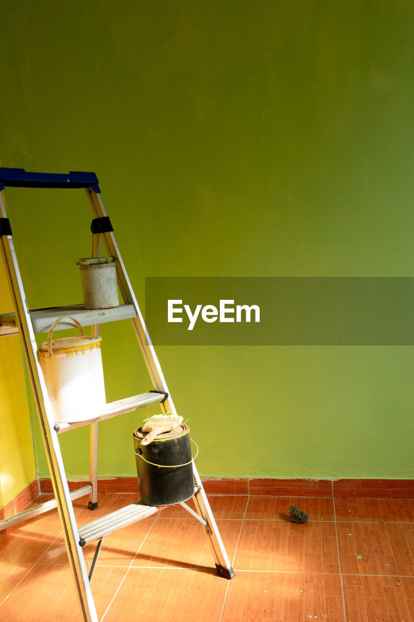 Renovation of a room and wall with fresh paint with text space and ladder with paint buckets