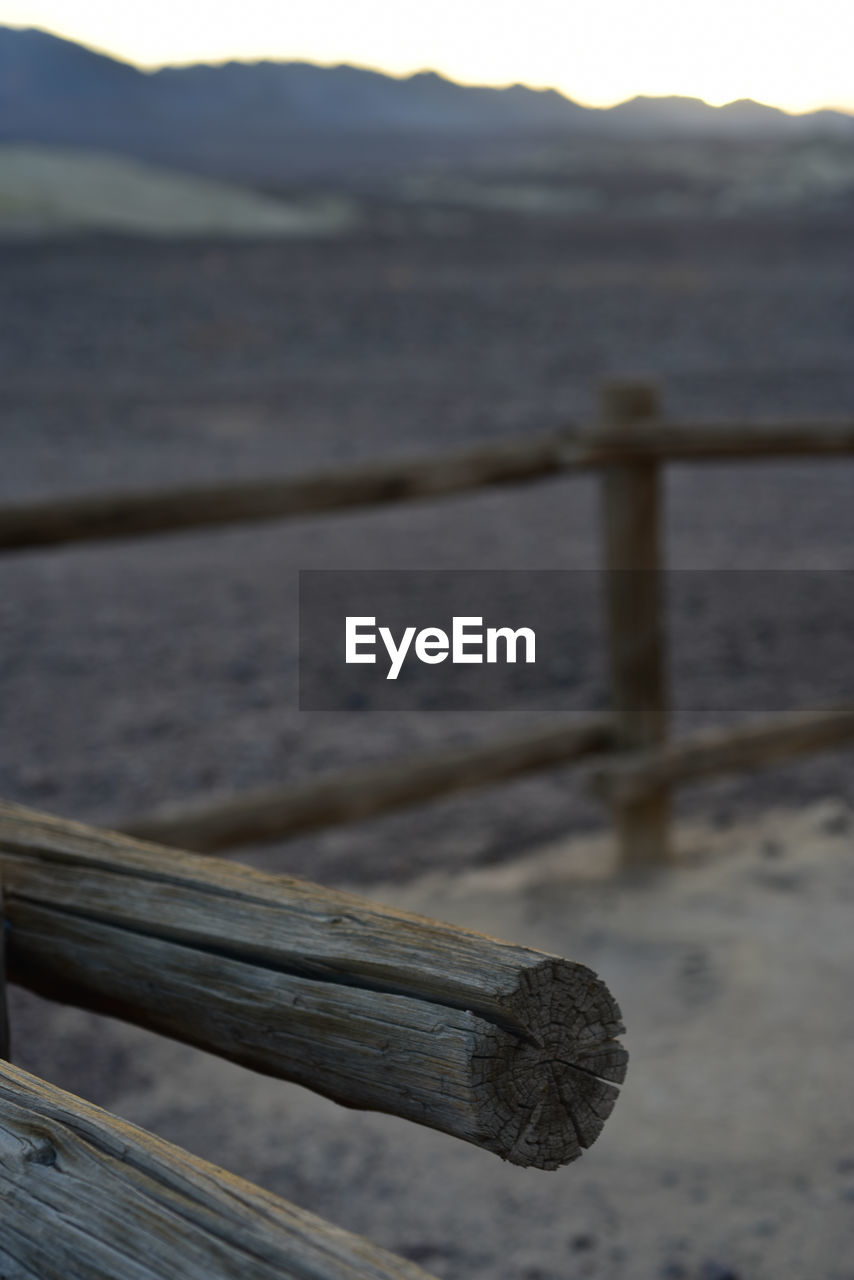 CLOSE-UP OF WOOD AGAINST BLURRED BACKGROUND