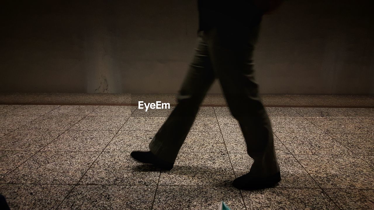 LOW SECTION OF MAN STANDING ON FLOORING