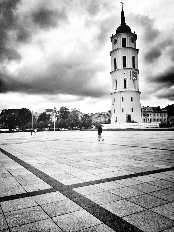 PEOPLE WALKING ON CITY STREET AGAINST CLOUDY SKY