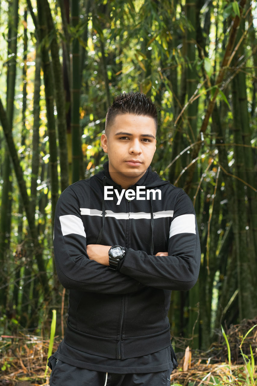 Young latin man in the middle of a beautiful bamboo forest in the majestic colombian mountains