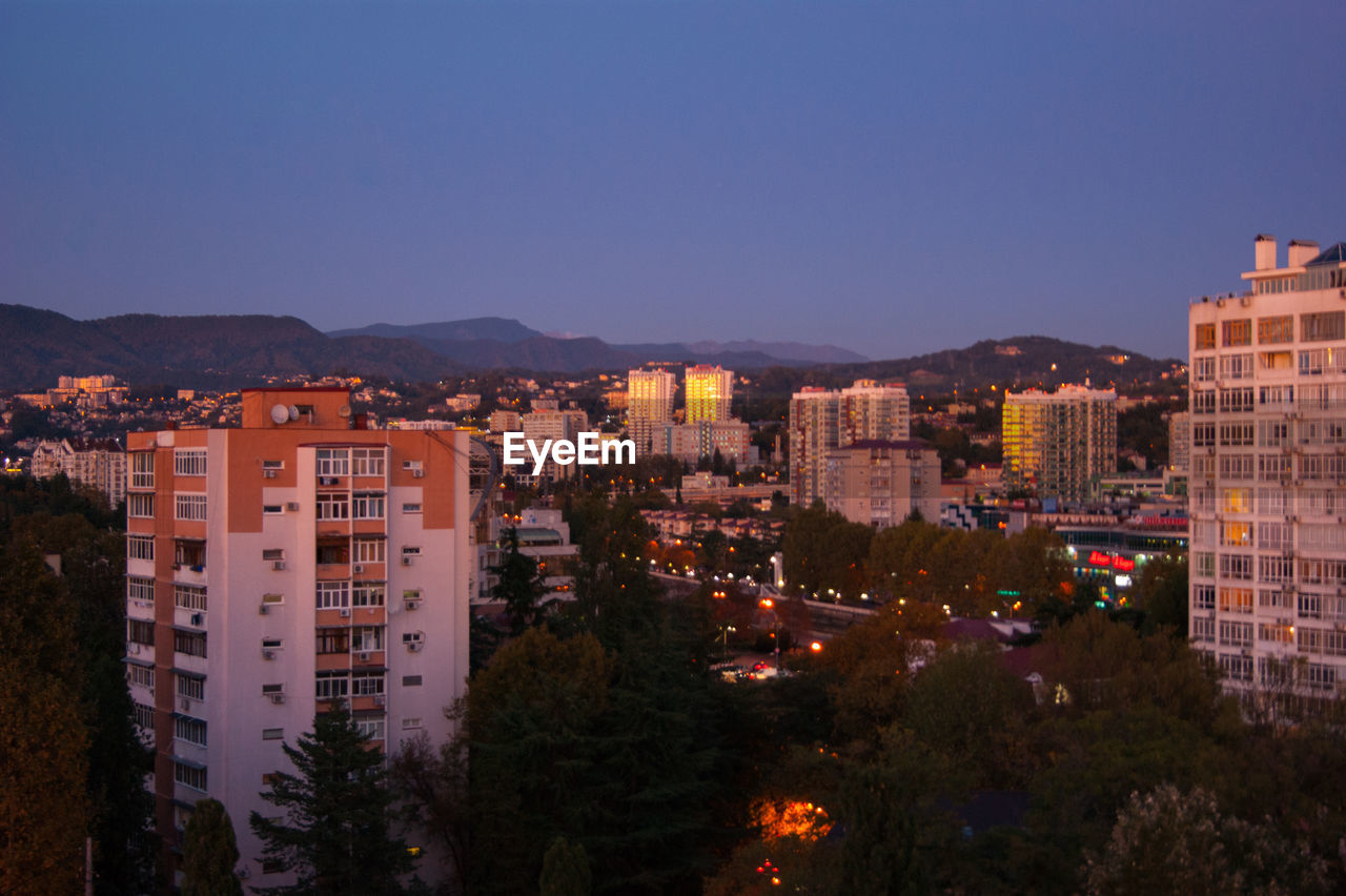 High angle view of buildings against clear sky at night