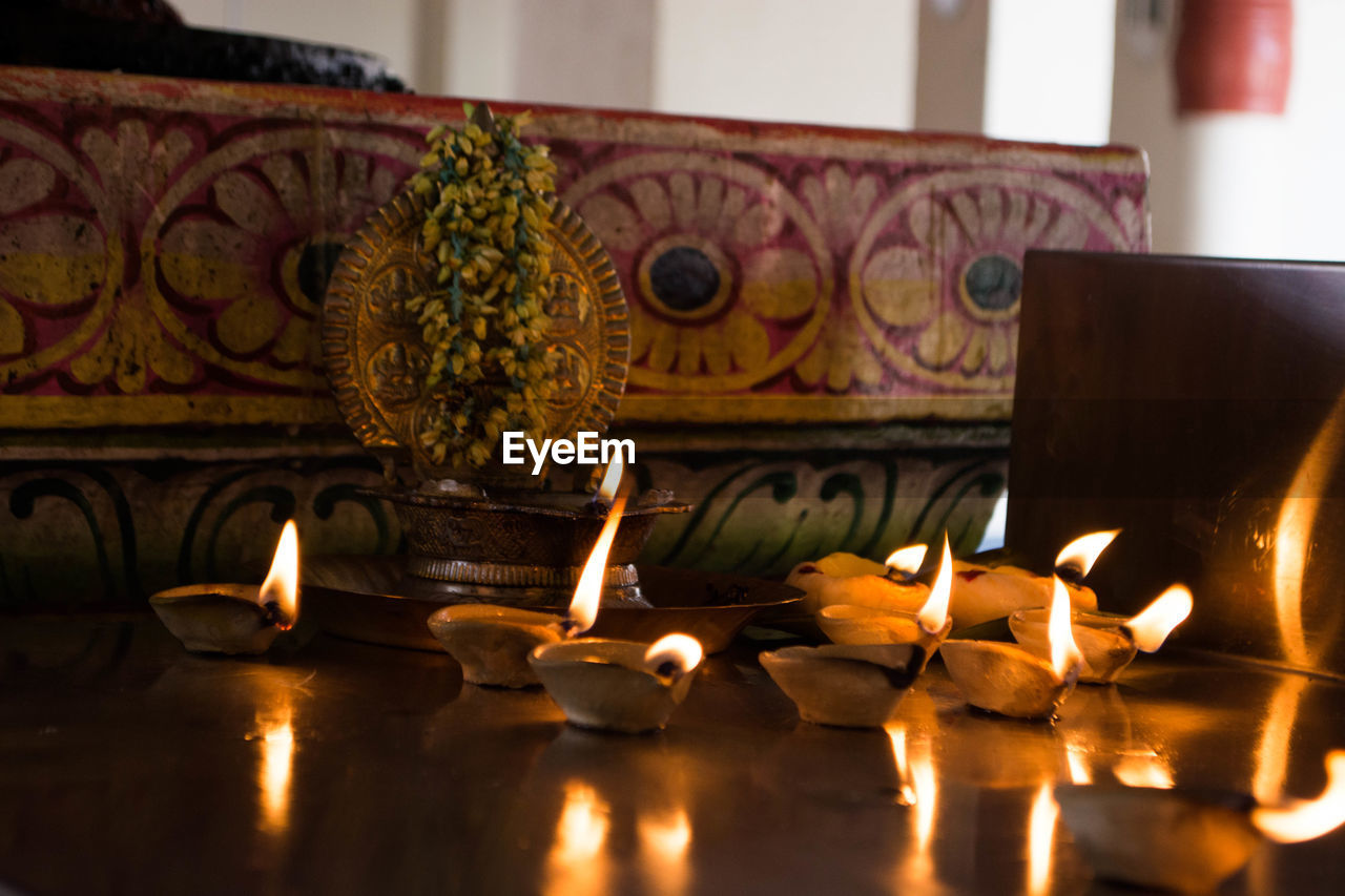 Close-up of illuminated candles on table