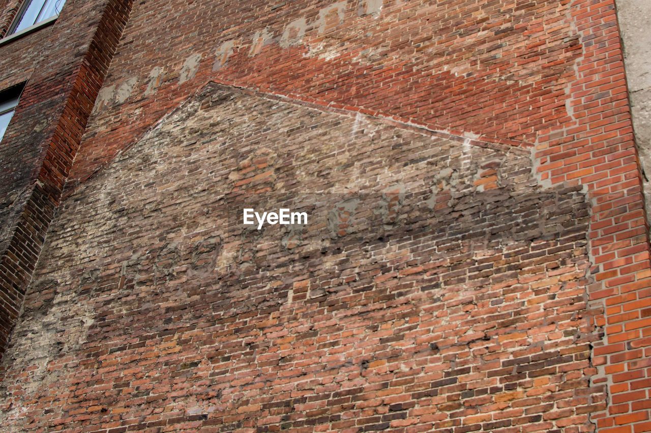 FULL FRAME SHOT OF BRICK WALL WITH BUILDING