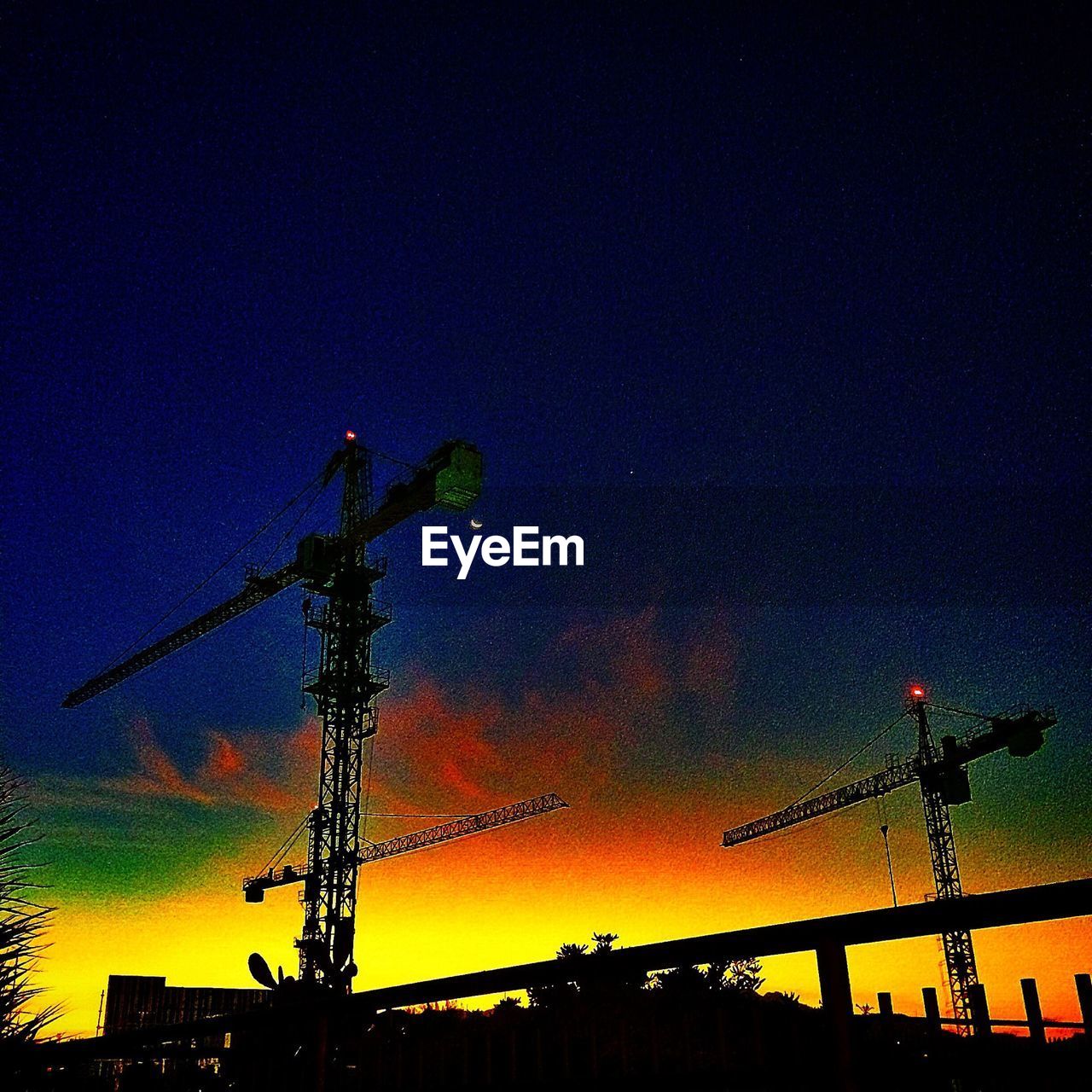 LOW ANGLE VIEW OF CRANES AGAINST SKY