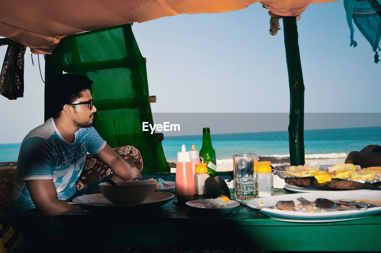 View of man eating at restaurant at beach