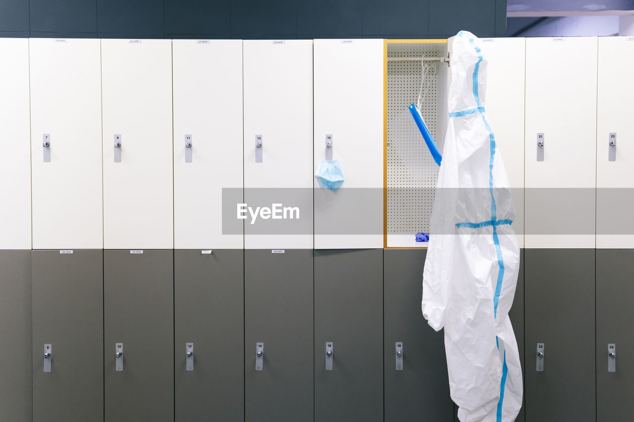 Protective wear and face shield hanging on locker in hospital