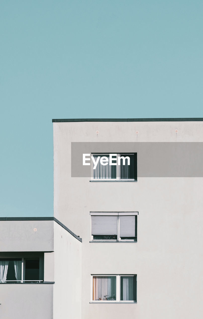 Three windows of a prefabricated building against clear sky in berlin spandau.