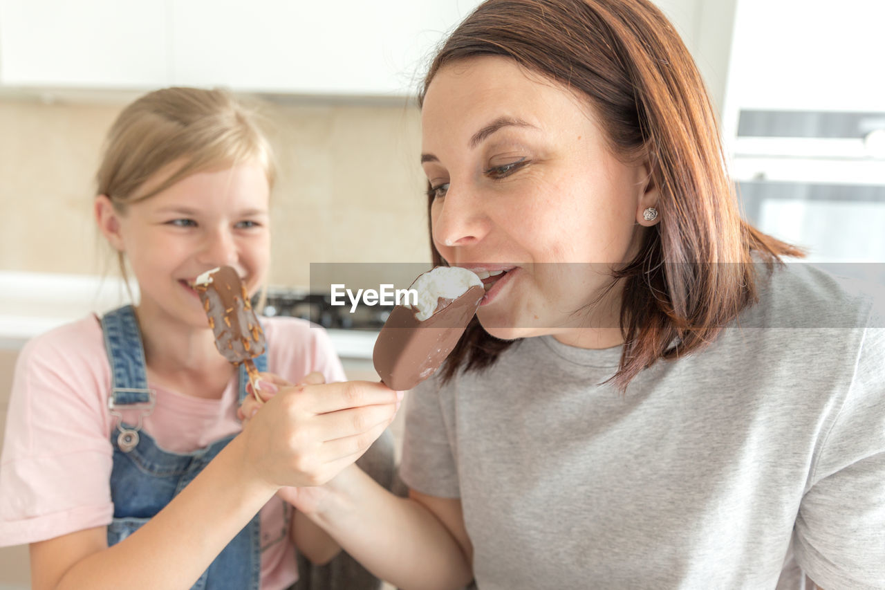 Mother and daughter eating ice cream at home