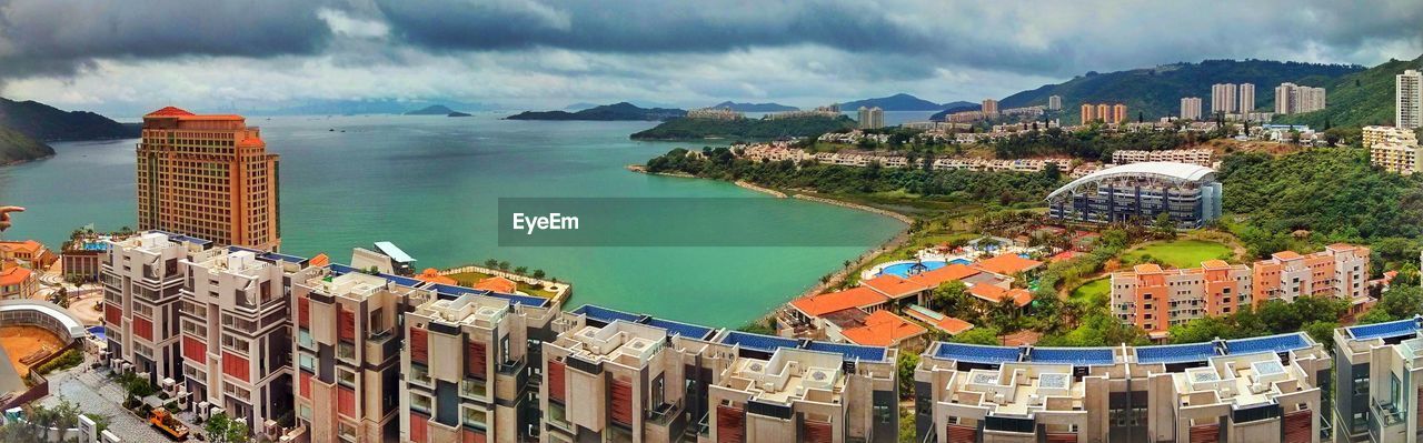 Panoramic view of buildings and sea against cloudy sky