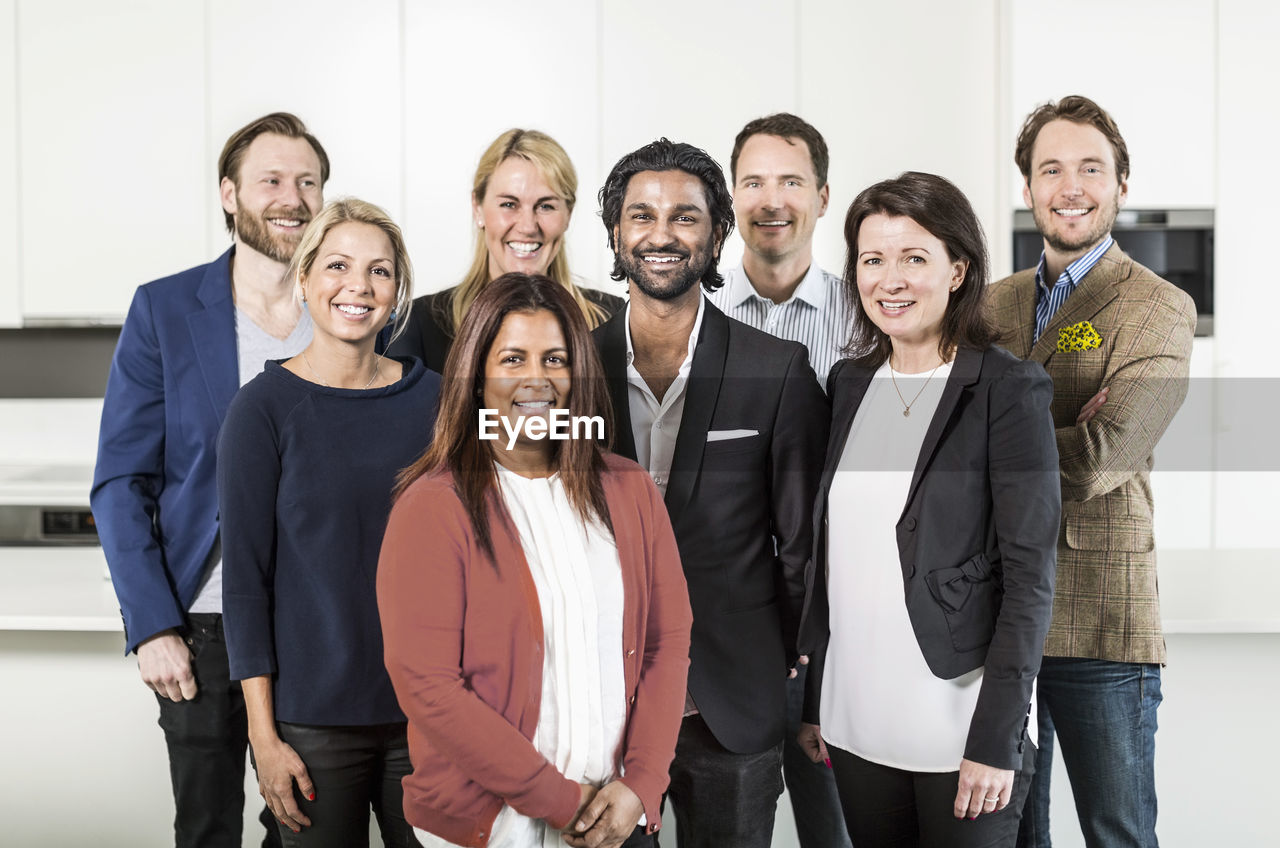 Portrait of multi-ethnic business people standing together in office