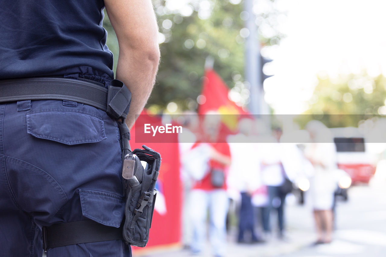 Police officer on duty during street protest, blurred protester in the background