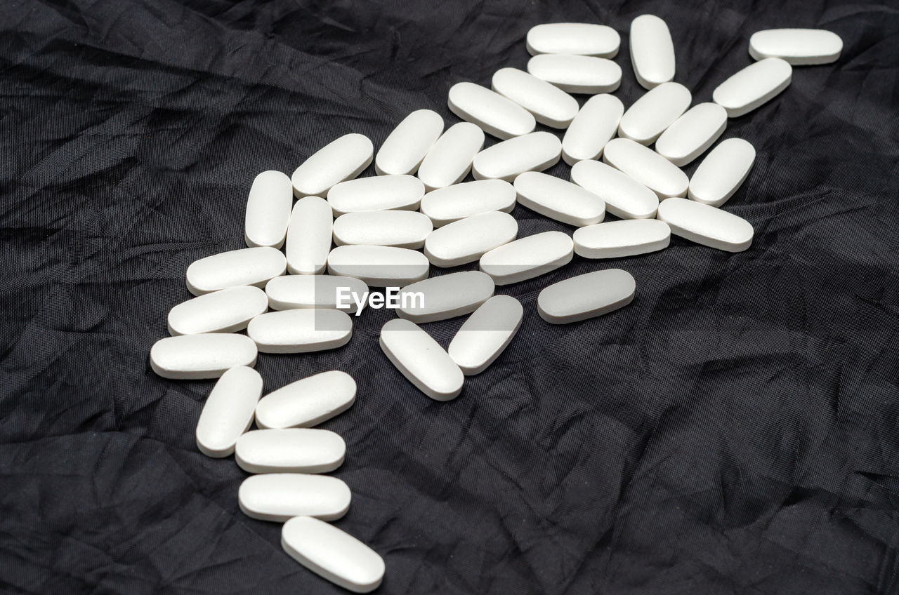 White sports vitamins pills on black background