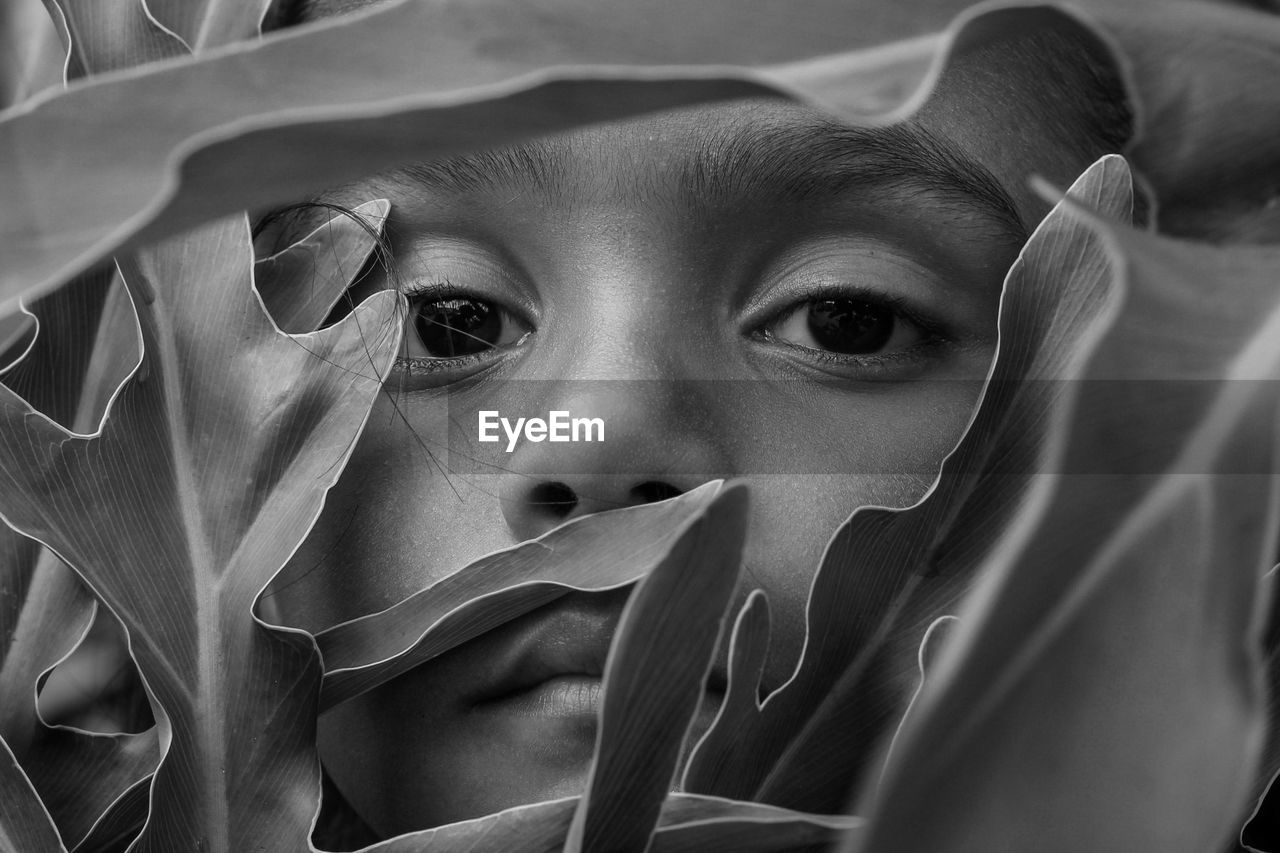 Close-up portrait of girl amidst plant