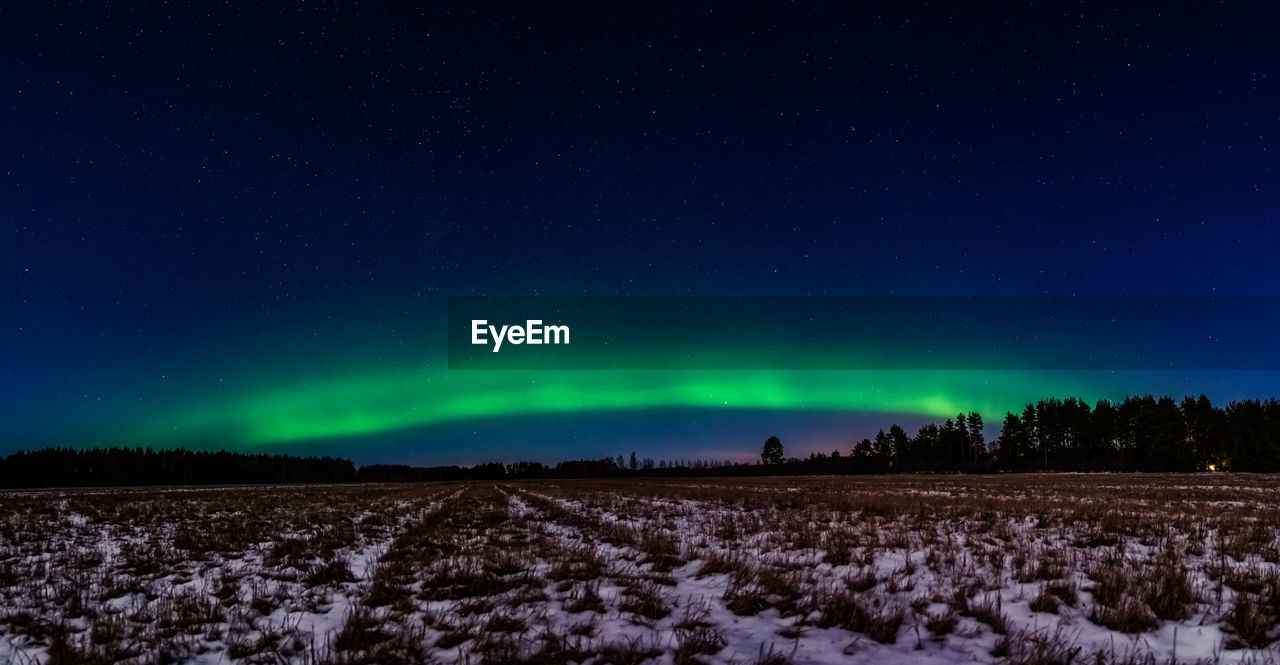 Scenic view of snowy field against sky at night