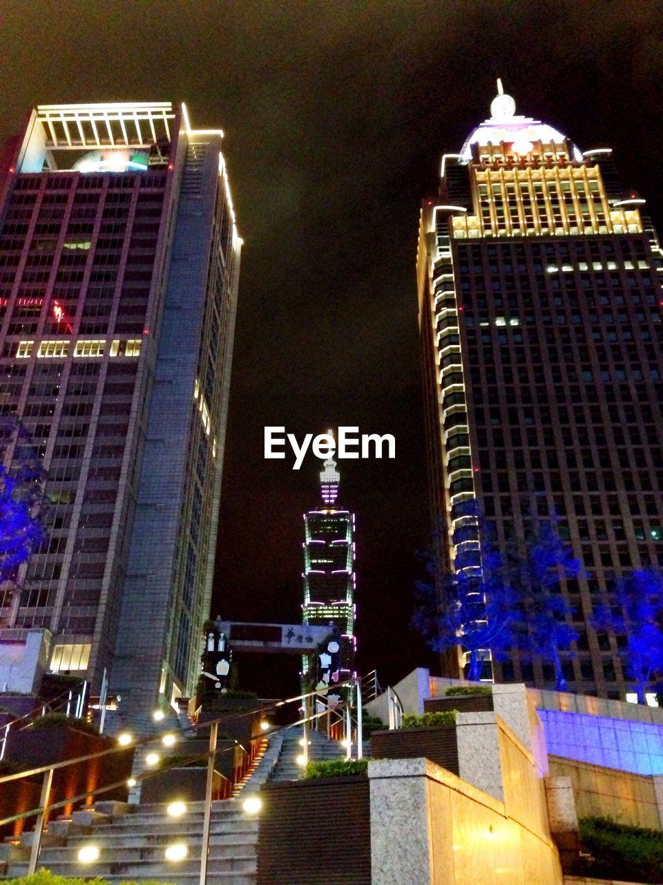 LOW ANGLE VIEW OF MODERN BUILDINGS AGAINST SKY AT NIGHT