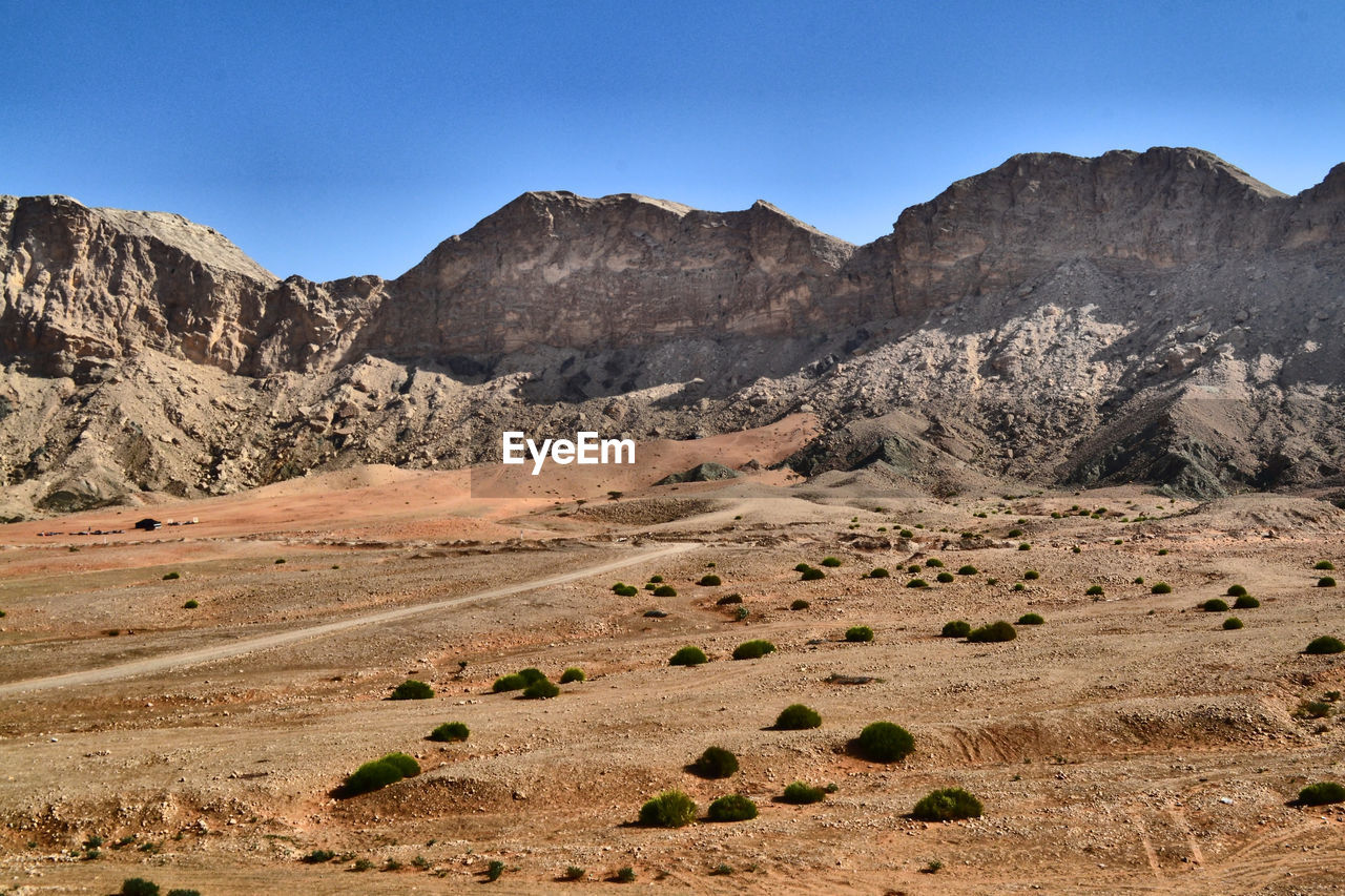 Scenic view of landscape and mountains against clear sky