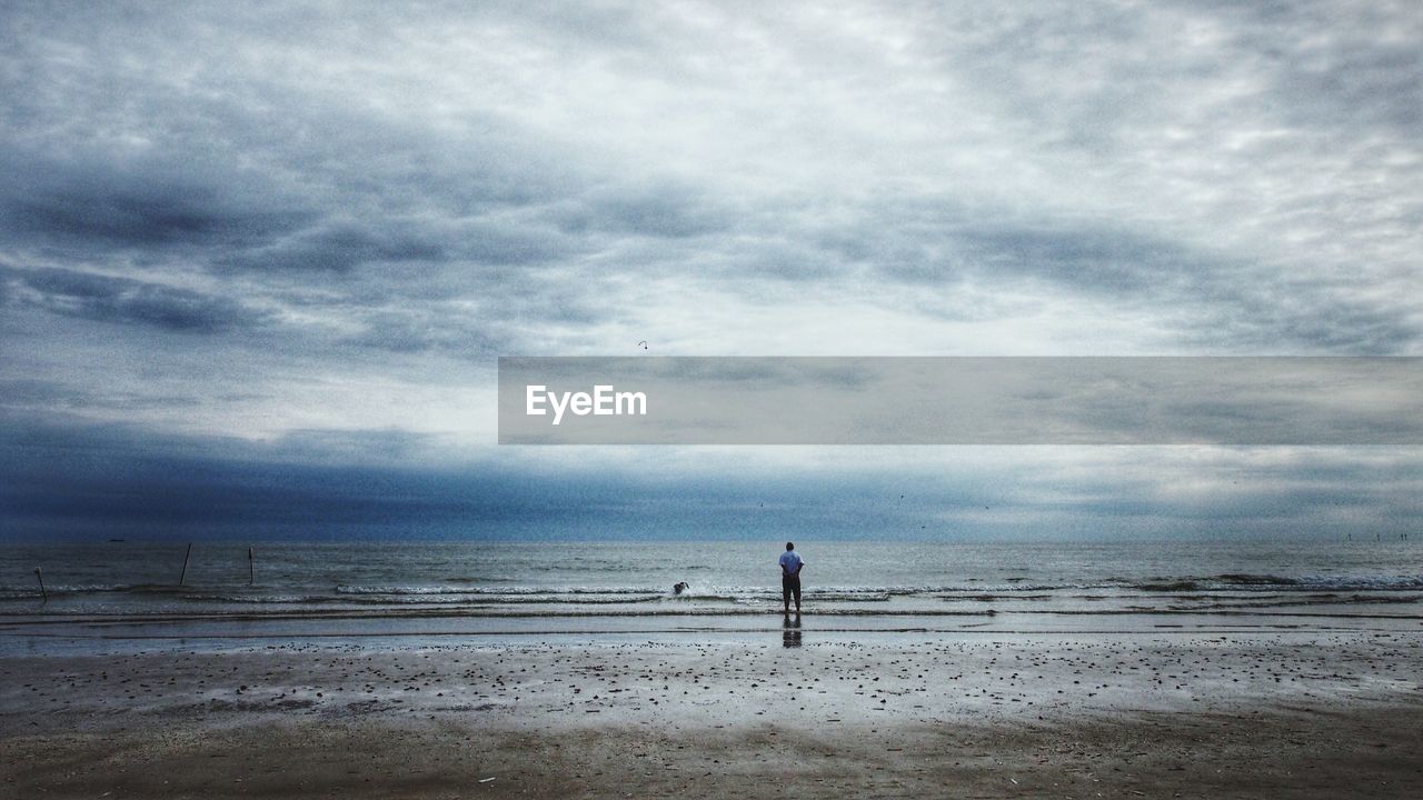 VIEW OF BEACH AGAINST CLOUDY SKY