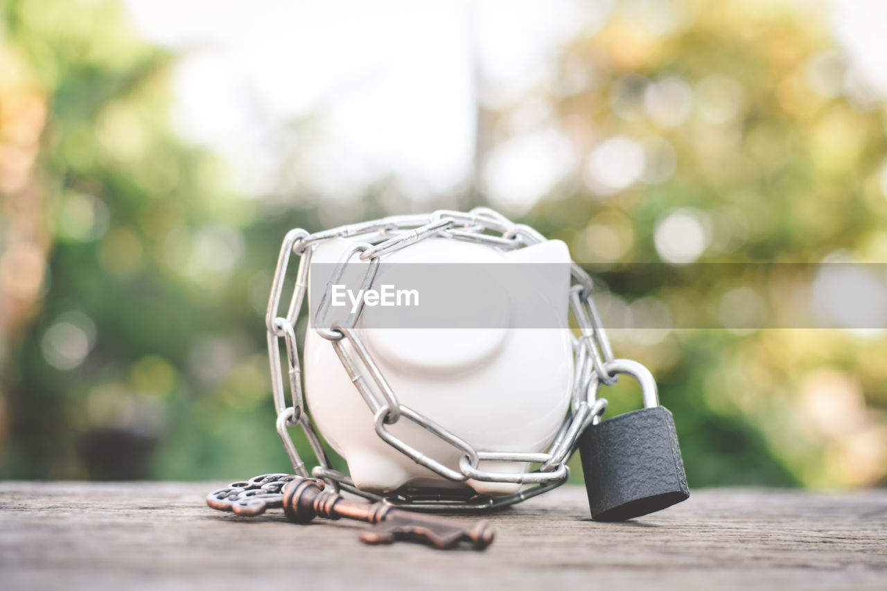 Close-up of piggy bank with key and lock on table