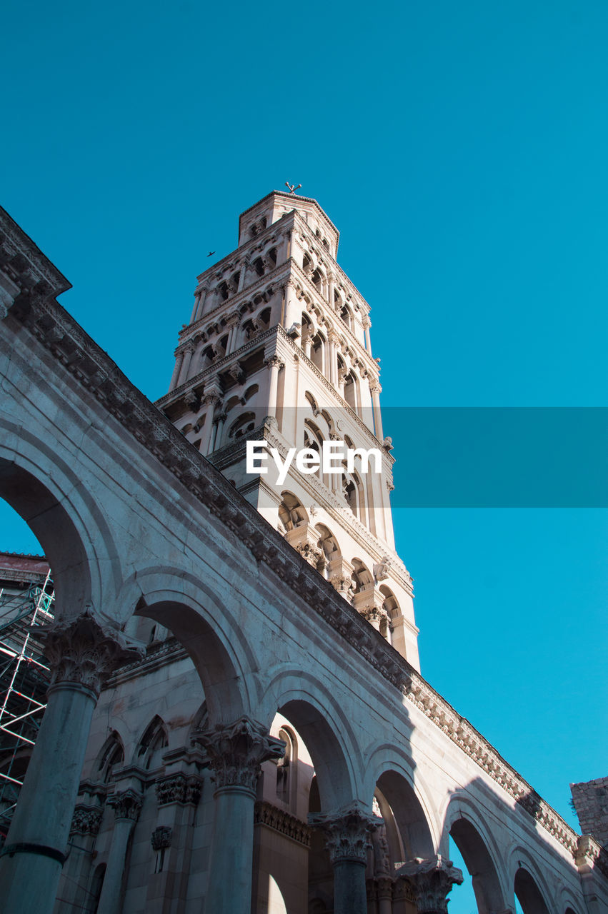 LOW ANGLE VIEW OF HISTORIC BUILDING AGAINST BLUE SKY