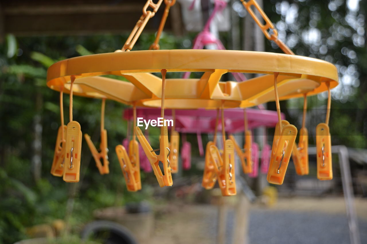Close-up of clothes pegs hanging from plastic clothesline