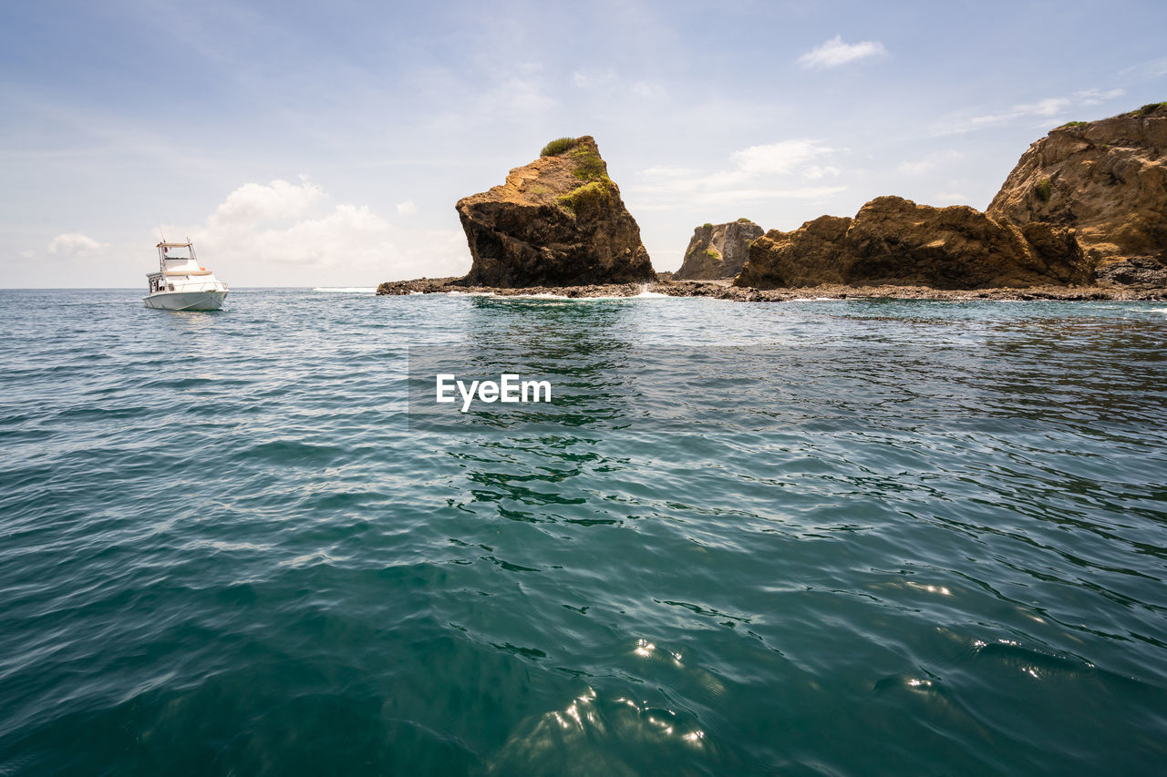 Scenic view of rock formation in sea against sky