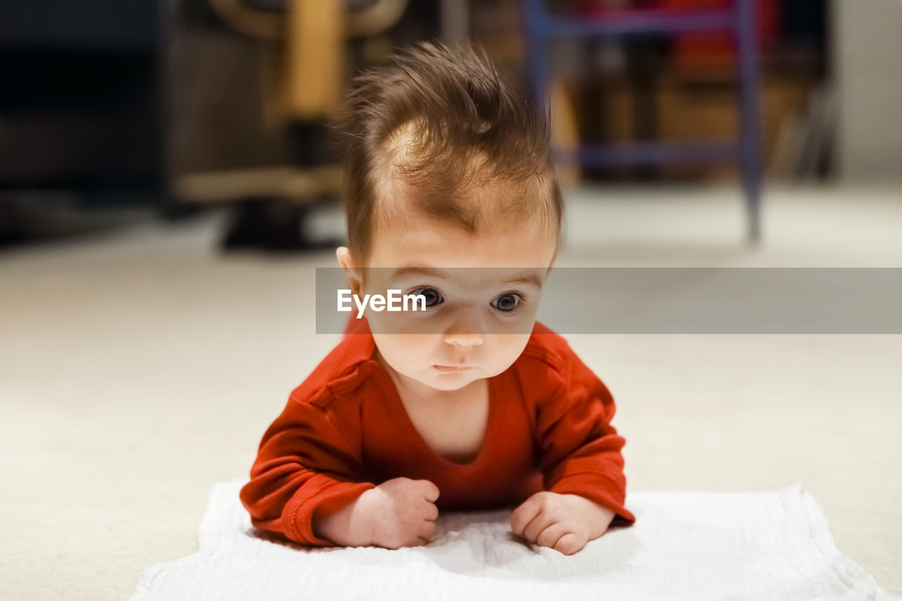 PORTRAIT OF CUTE BABY GIRL SITTING ON SOFA