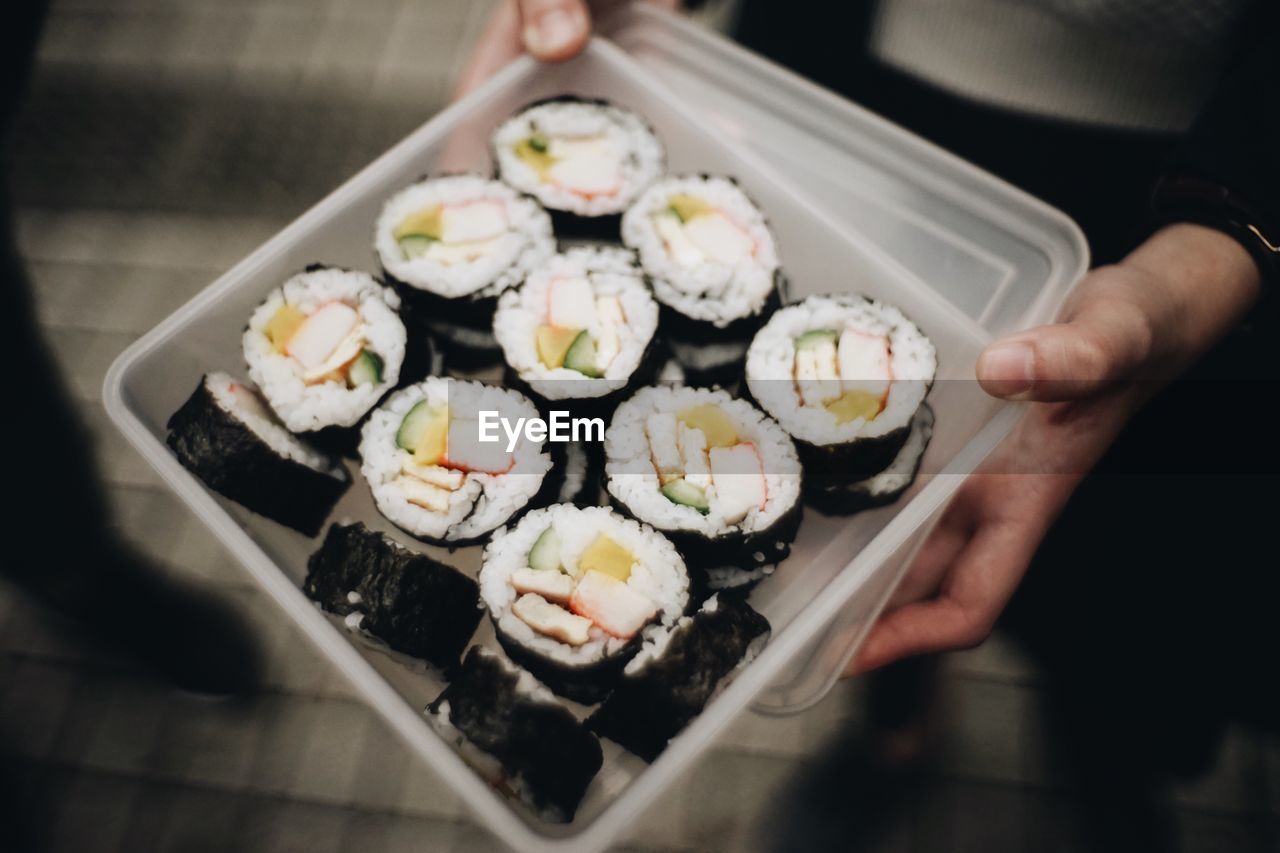 Close-up of waiter serving maki sushi in restaurant