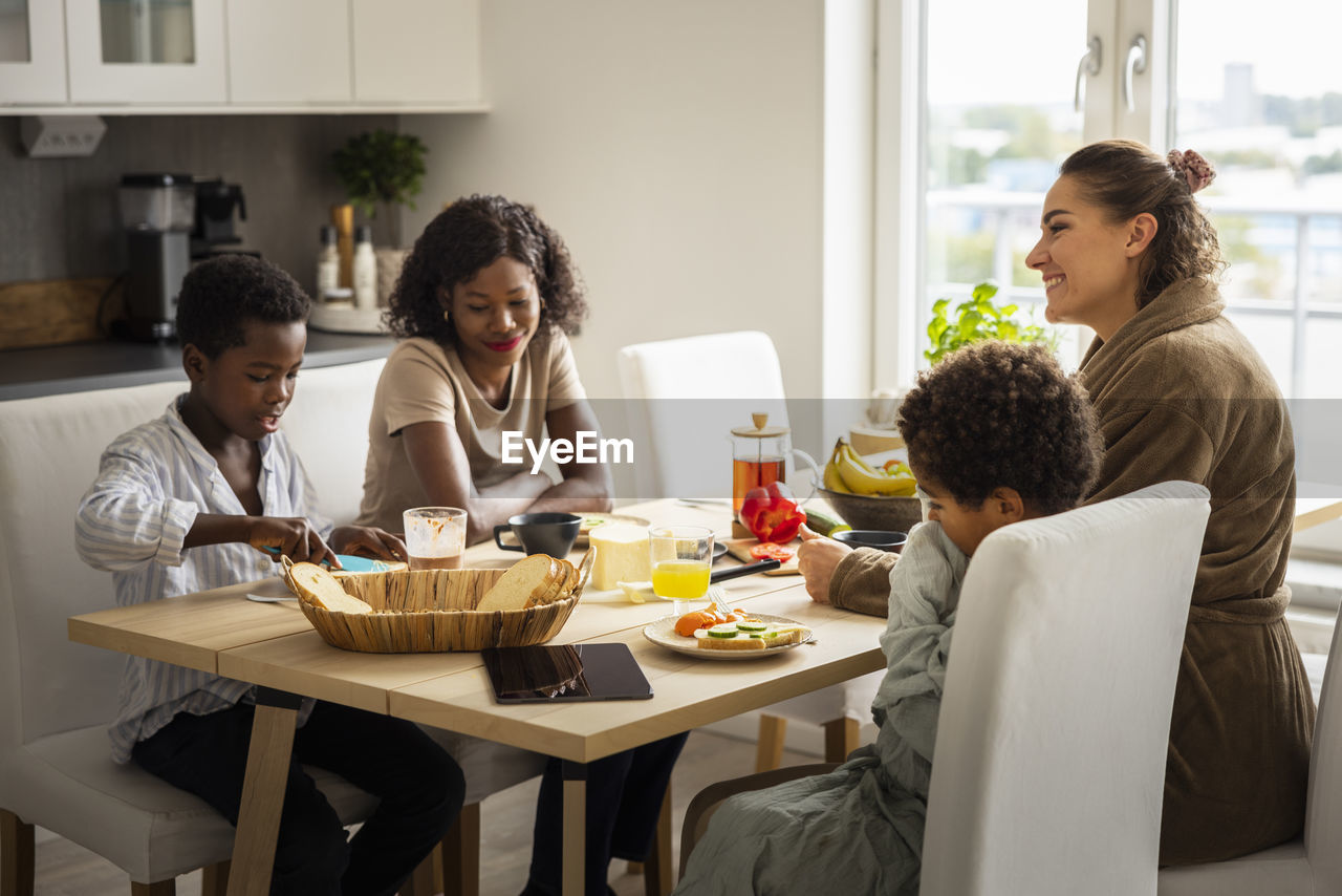 Mothers and sons eating breakfast