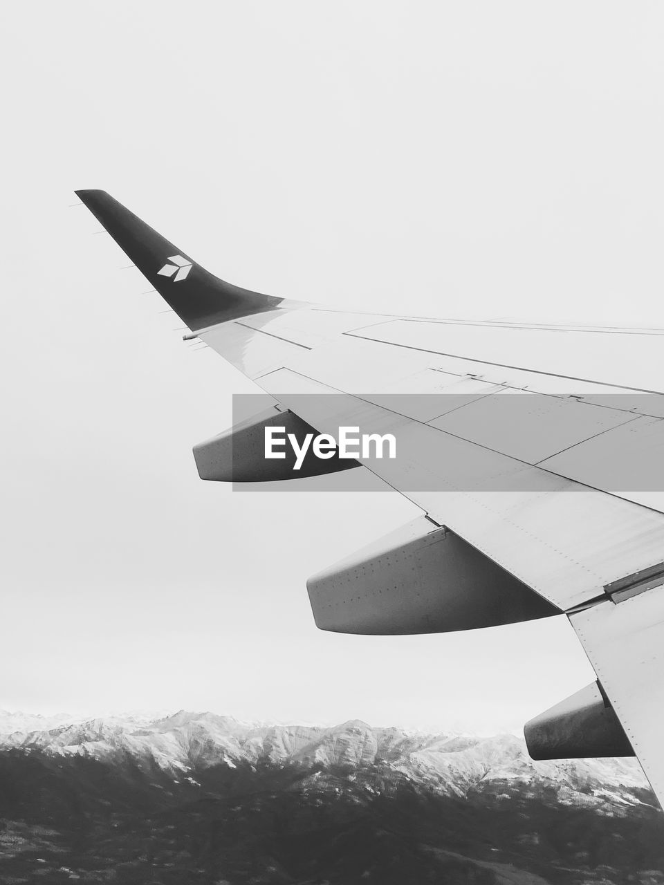 airplane, air vehicle, aircraft wing, aircraft, vehicle, flying, transportation, mode of transportation, aviation, airliner, jet aircraft, travel, nature, sky, no people, military aircraft, fighter aircraft, snow, white, wing, mountain, day, mid-air, environment, black and white, monochrome, narrow-body aircraft, outdoors, cold temperature, aerospace industry, winter, air force, journey, motion