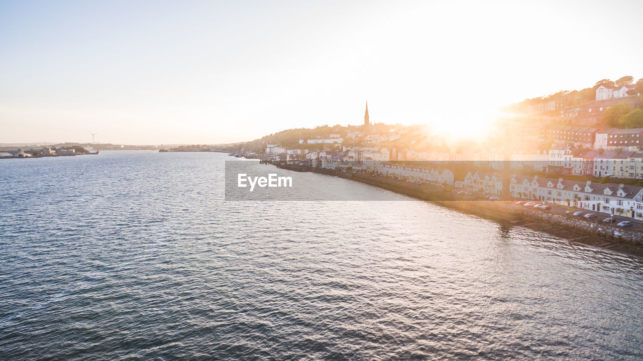 SCENIC VIEW OF RIVER AGAINST CLEAR SKY AT SUNSET