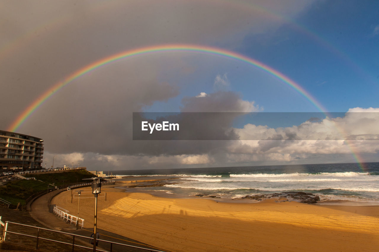 Scenic view of rainbow over sea against sky