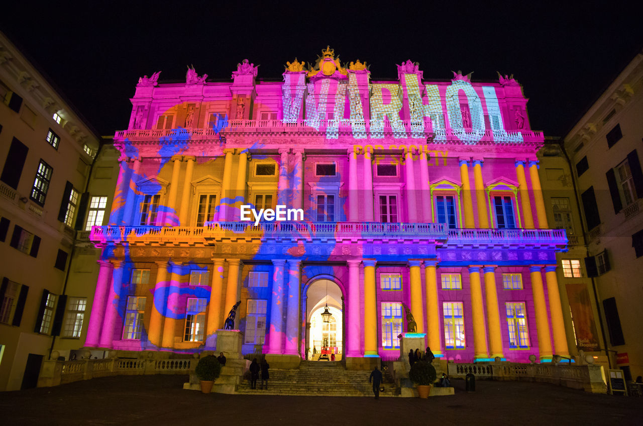 LOW ANGLE VIEW OF ILLUMINATED BUILDING AGAINST SKY