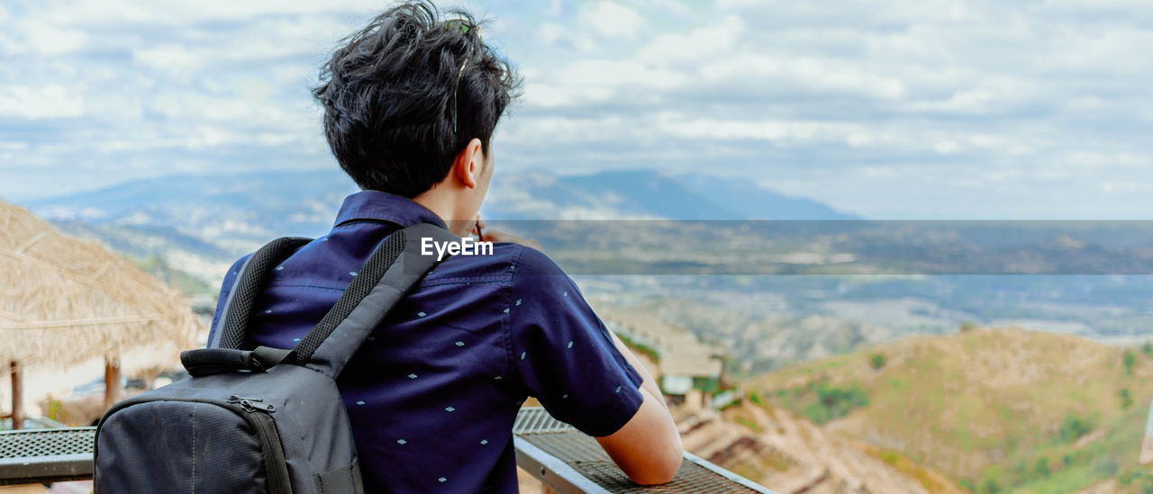 Rear view of man looking at landscape from observation point