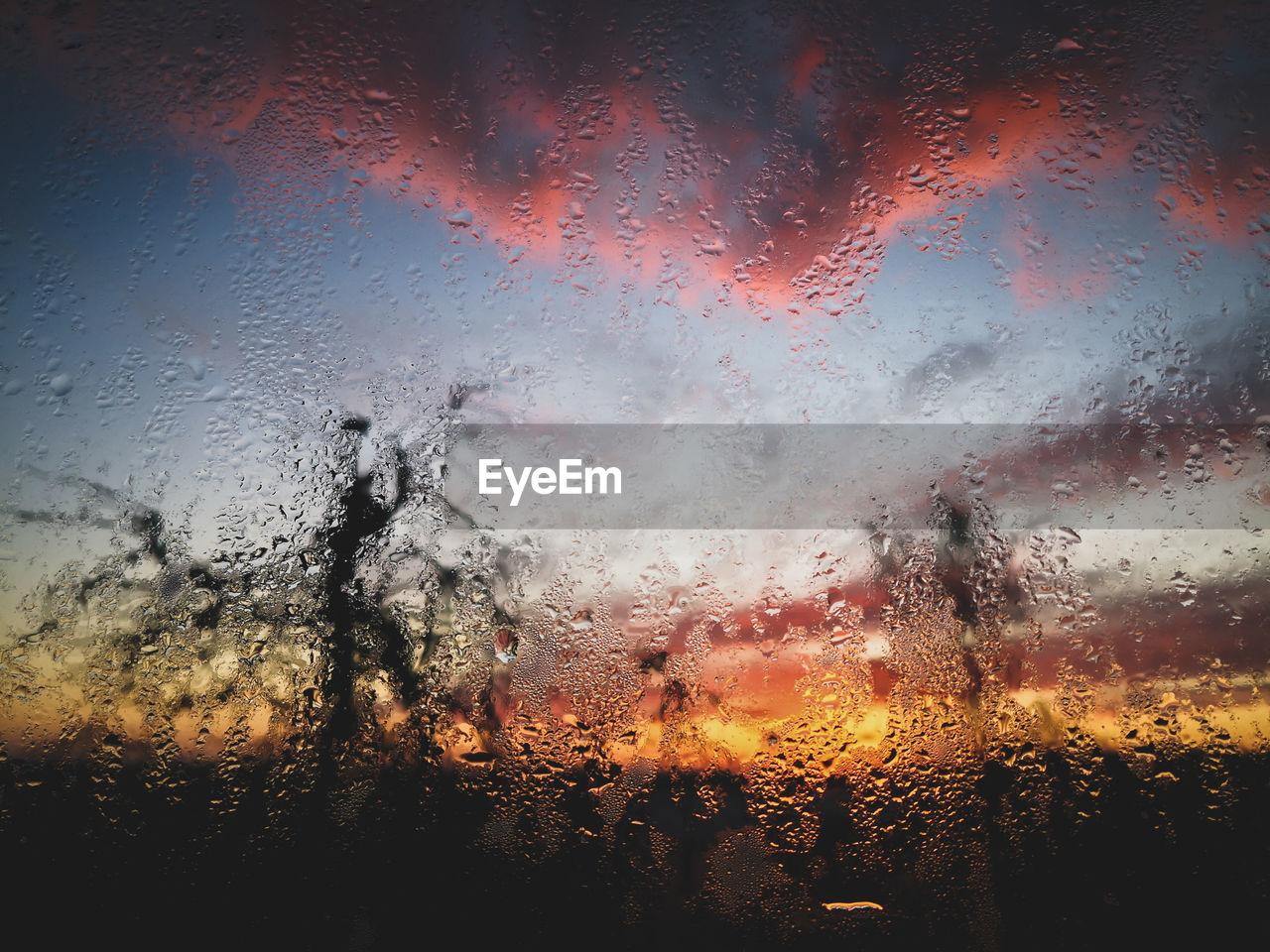 Full frame shot of wet window during sunset